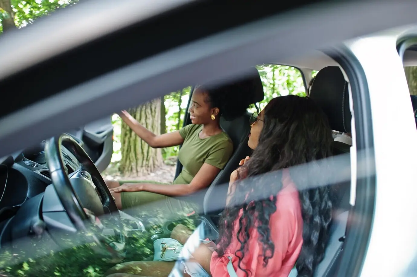 Two African American female friends having fun in the car