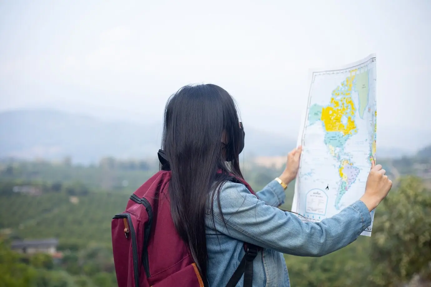 A traveling girl seeking the right direction on a map.